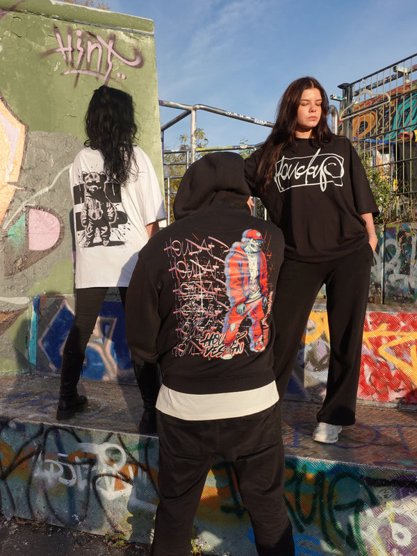 Drei Personen, zwei Rückansichten, eine Vorderansicht: eine Person trägt ein weißes Oversize-Shirt (Rücken), eine Person ein weißes Oversize-Shirt (Front), dritte Person einen schwarzen Oversize Zip Hoodie (Front), lässiger Streetstyle